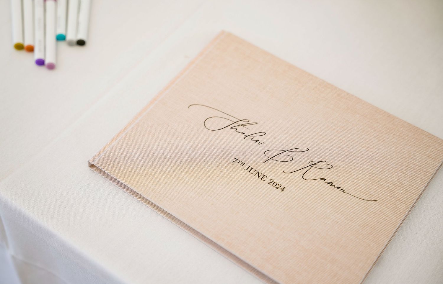 An elegant thank you note with calligraphy writing sits on a white surface.