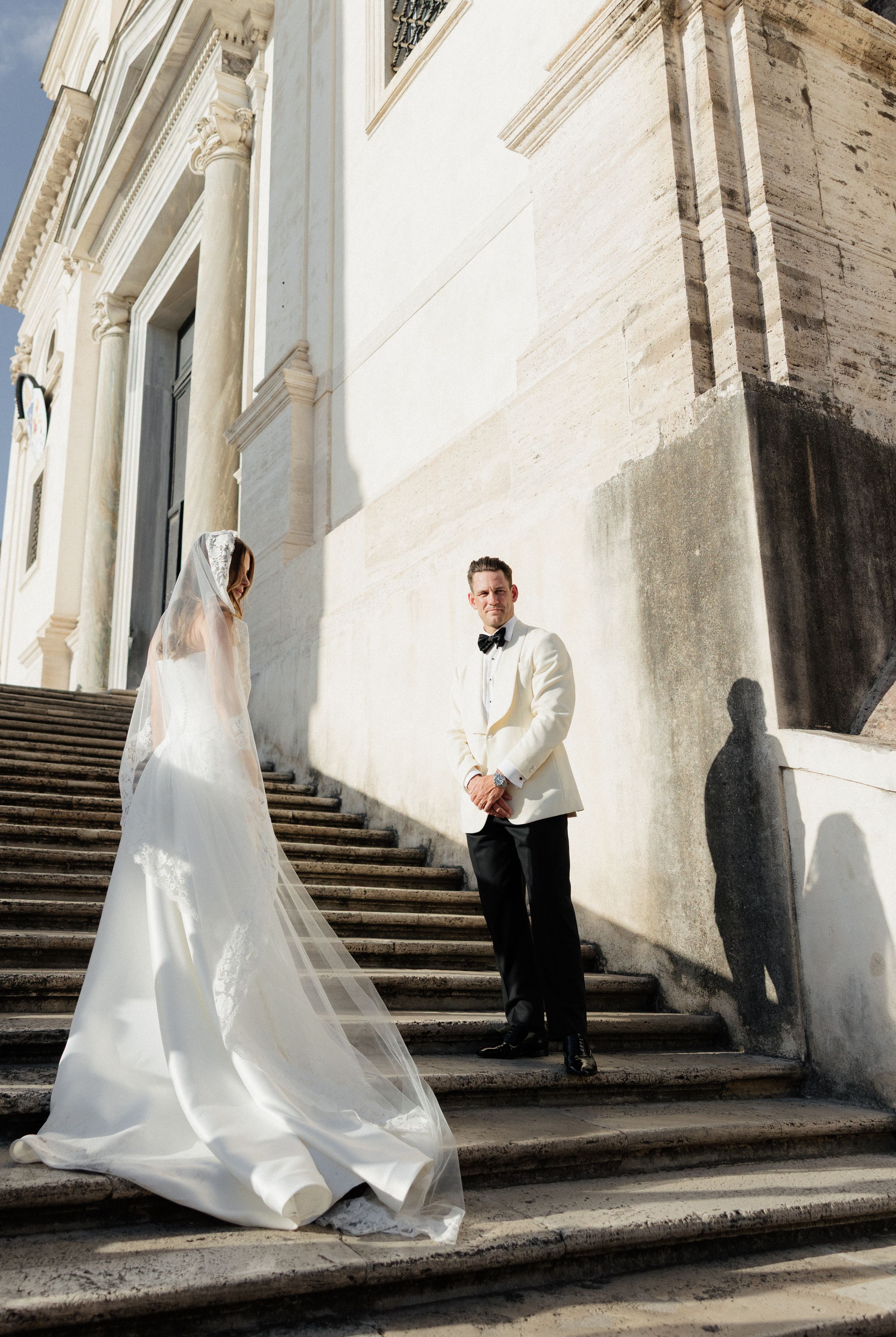 A sequence of wedding photos showing a bride and groom on elegant stone steps in a bright white architectural setting.