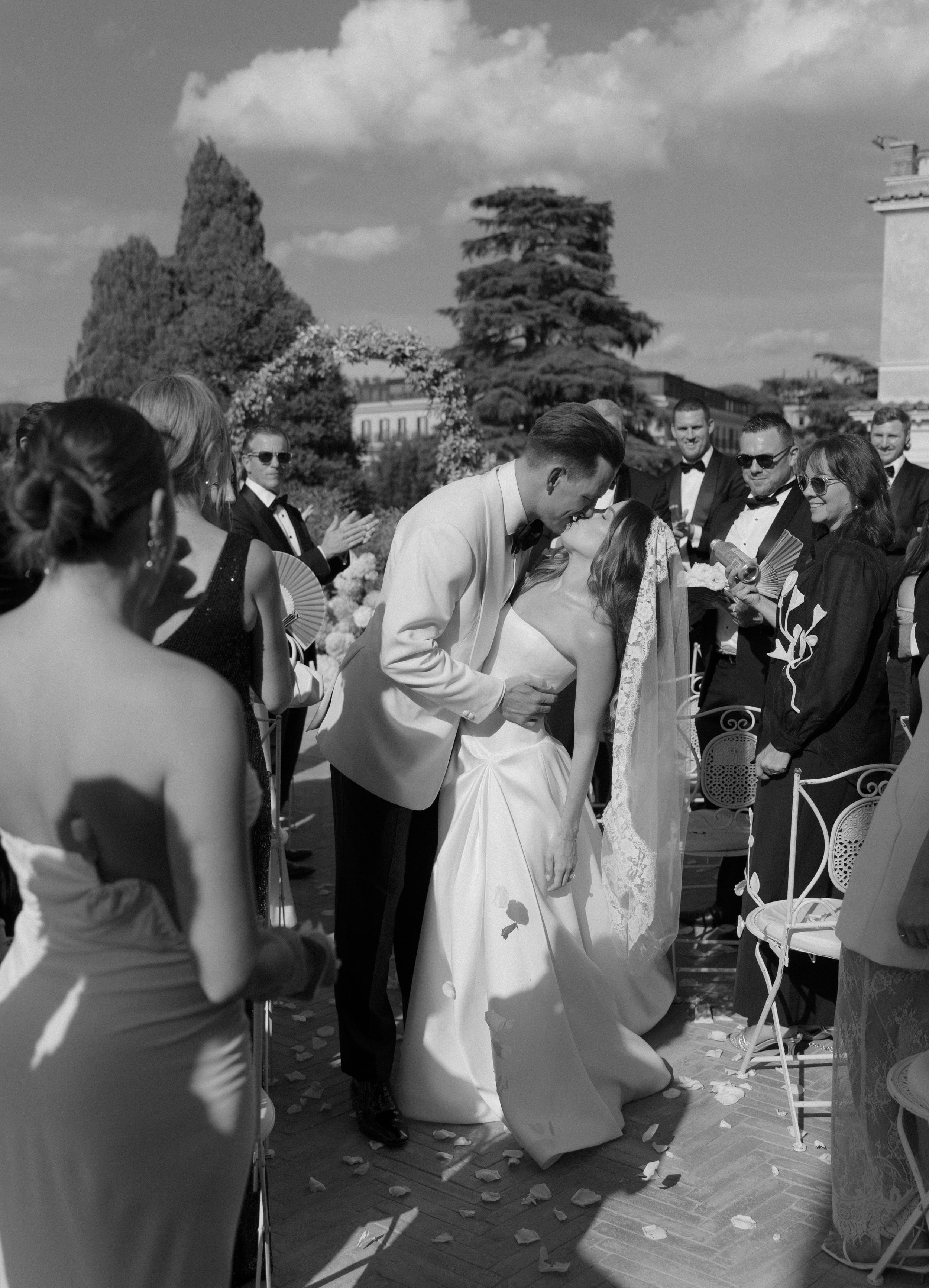 Black and white photo sequence showing wedding guests throwing confetti and celebrating at an outdoor ceremony.