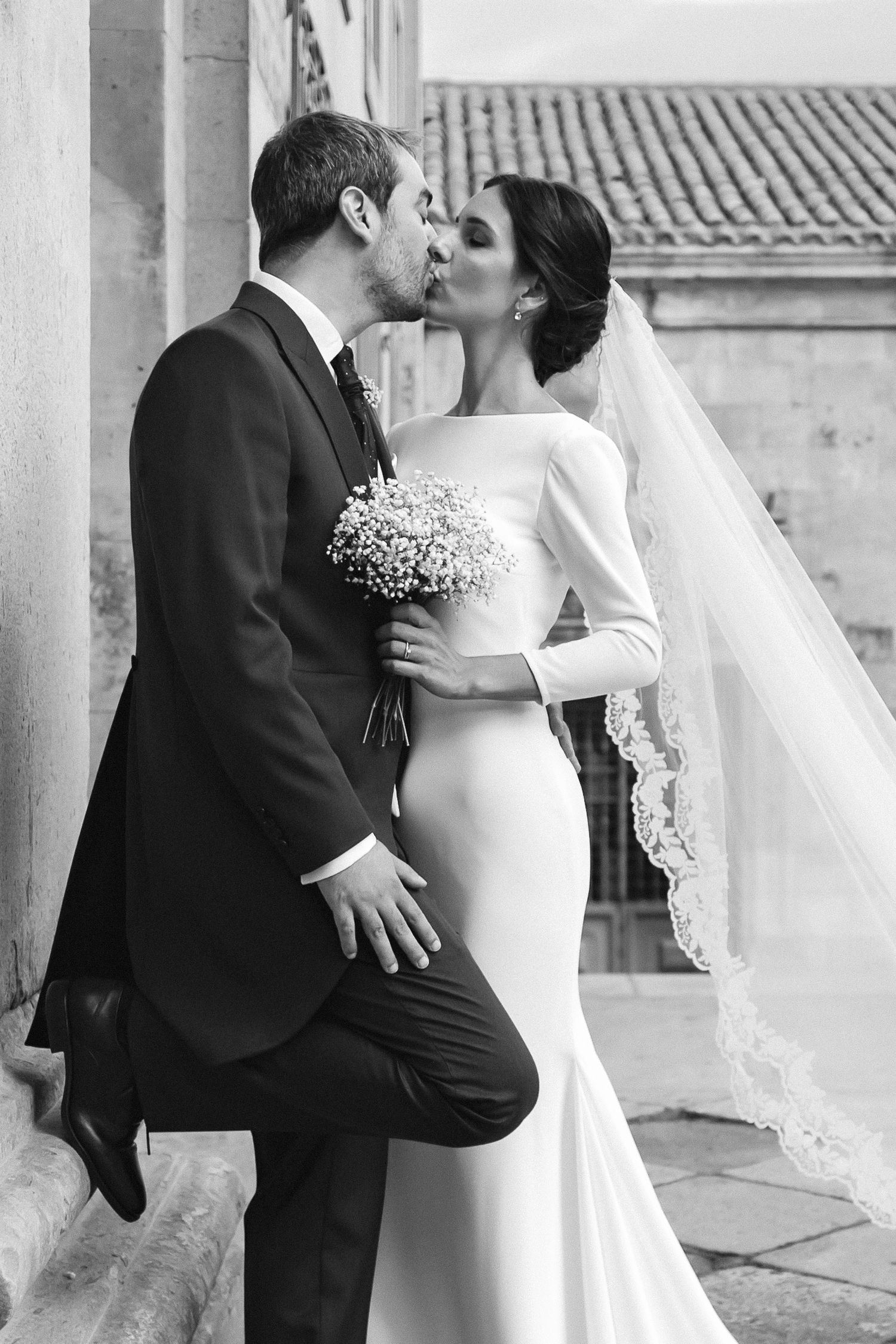 A couple dancing together during their wedding celebration, with the bride in an elegant white gown and groom in a tuxedo.