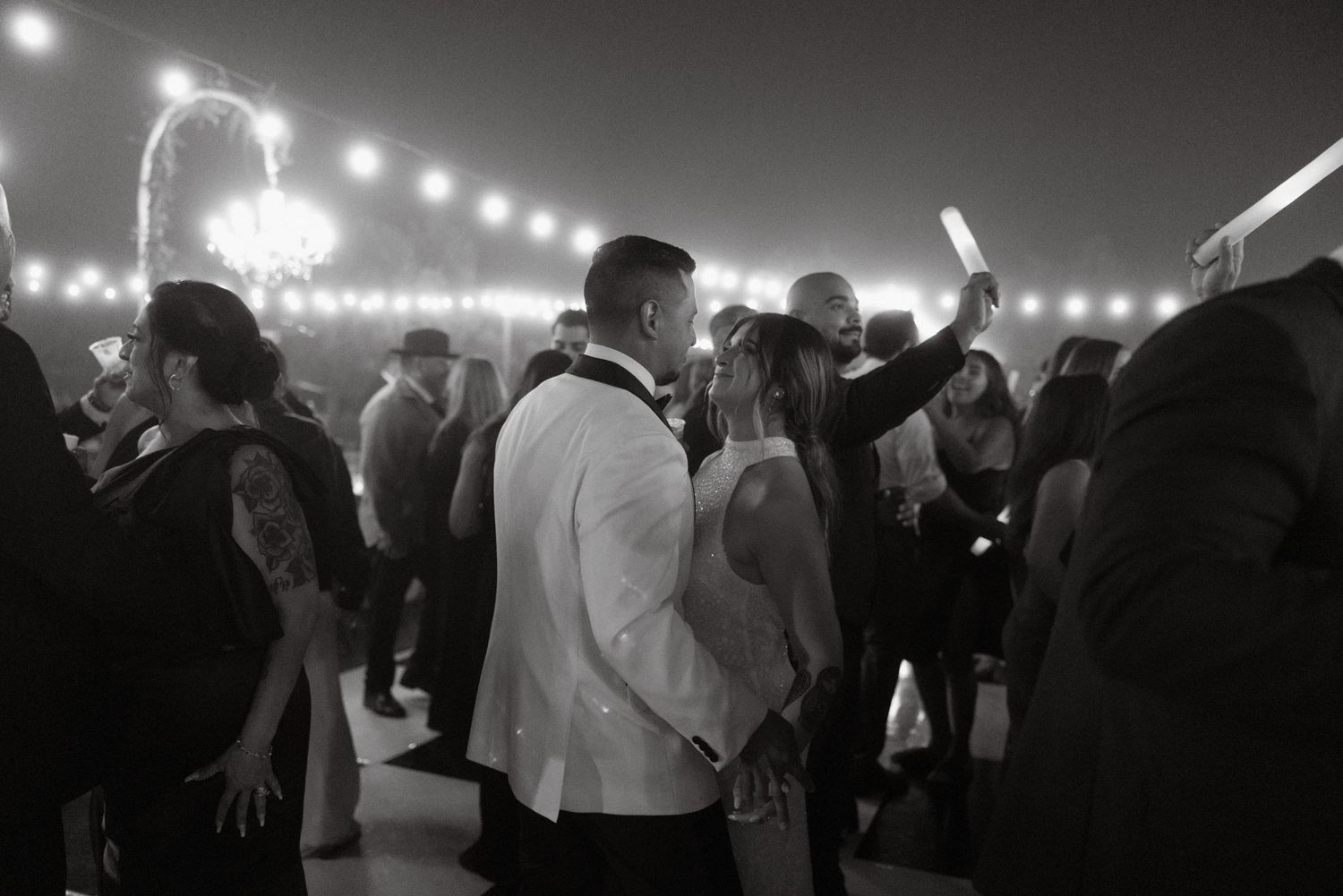 Black and white photo of bride and groom looking at each other on the dance floor