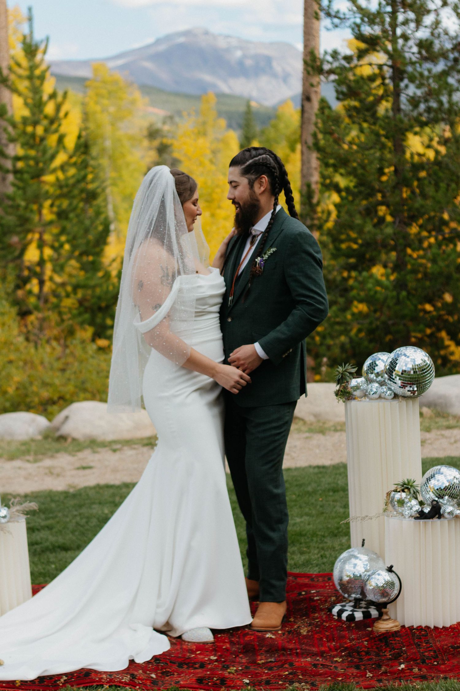 Wedding party celebrates outdoors with bridesmaids in pink dresses and couple in white dress and suit with bouquet. Candid wedding photo.