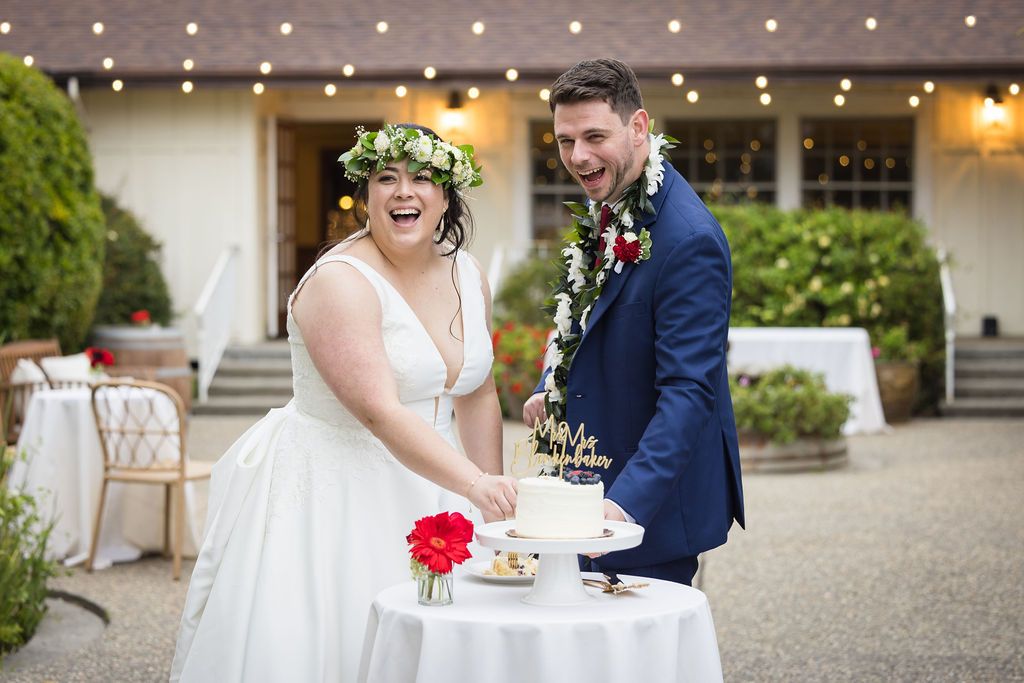 Black and white wedding photo of bride and groom sharing a romantic moment on the floor, groom wearing a floral lei.