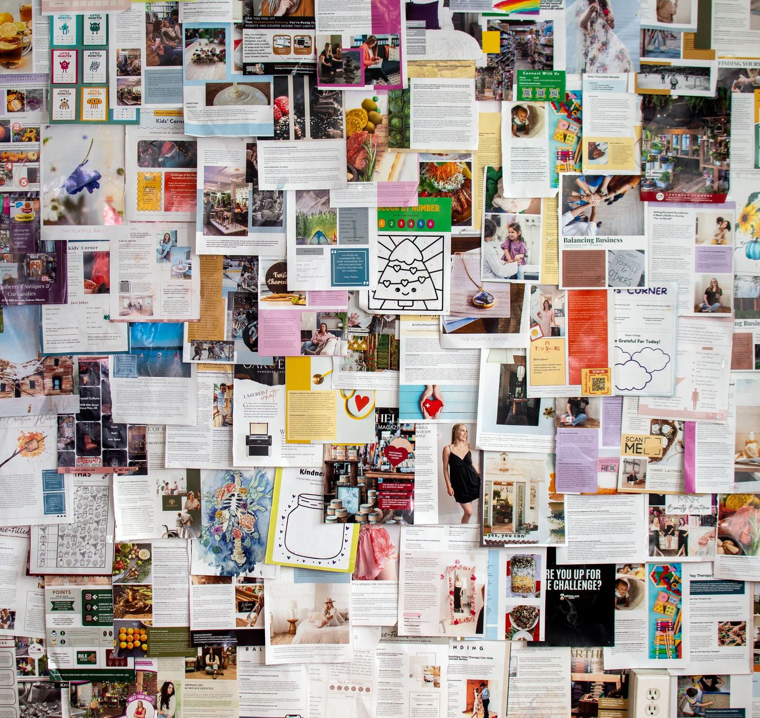 A colorful vision board covered with magazine clippings, photos, and inspirational text arranged in a collage.