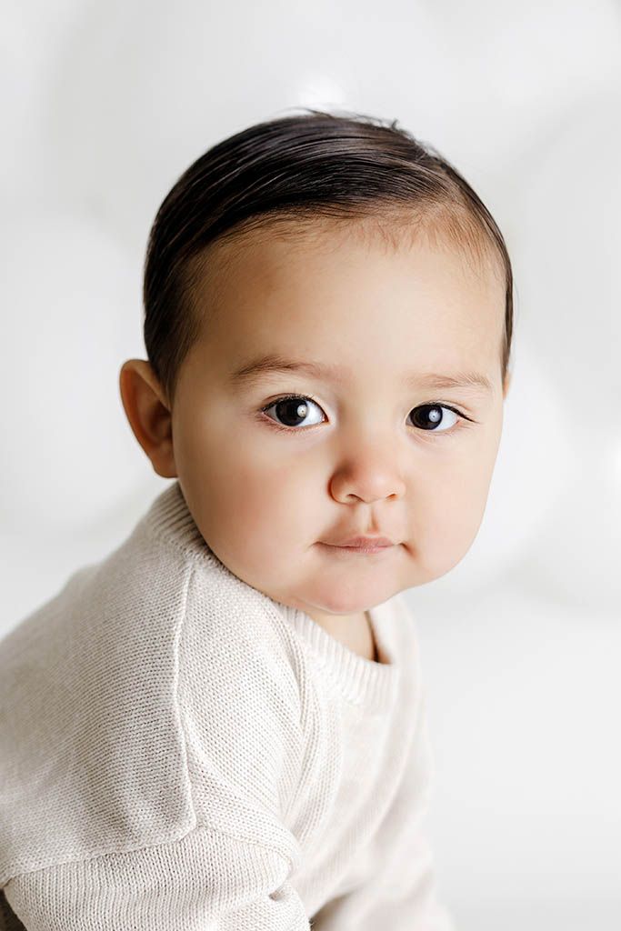 Close-up portrait of cute baby against white background by professional photographer in Winchester California.