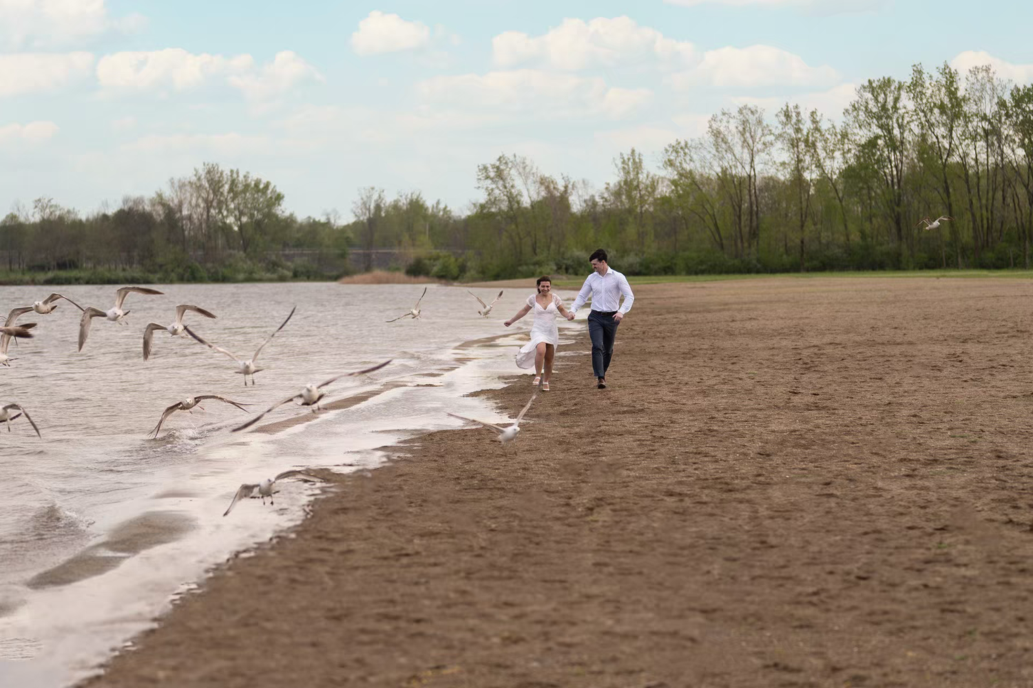 Couple walking hand in hand on sandy beach at Alum Creek Beach for Engagement Photos