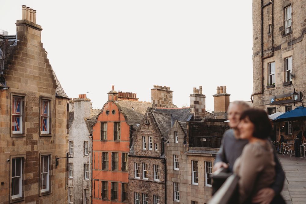 Historic stone buildings and architecture line a narrow cobblestone street in Edinburgh's Old Town.