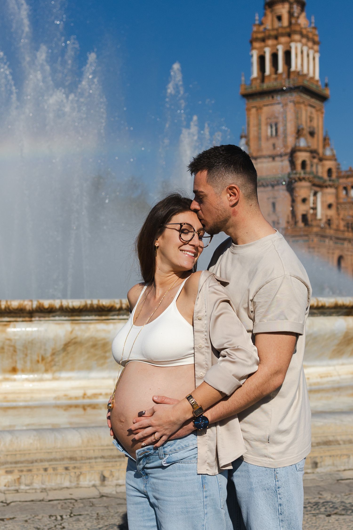 Couple sitting together on ornate tiled bench at Plaza de España in Seville, Spain.