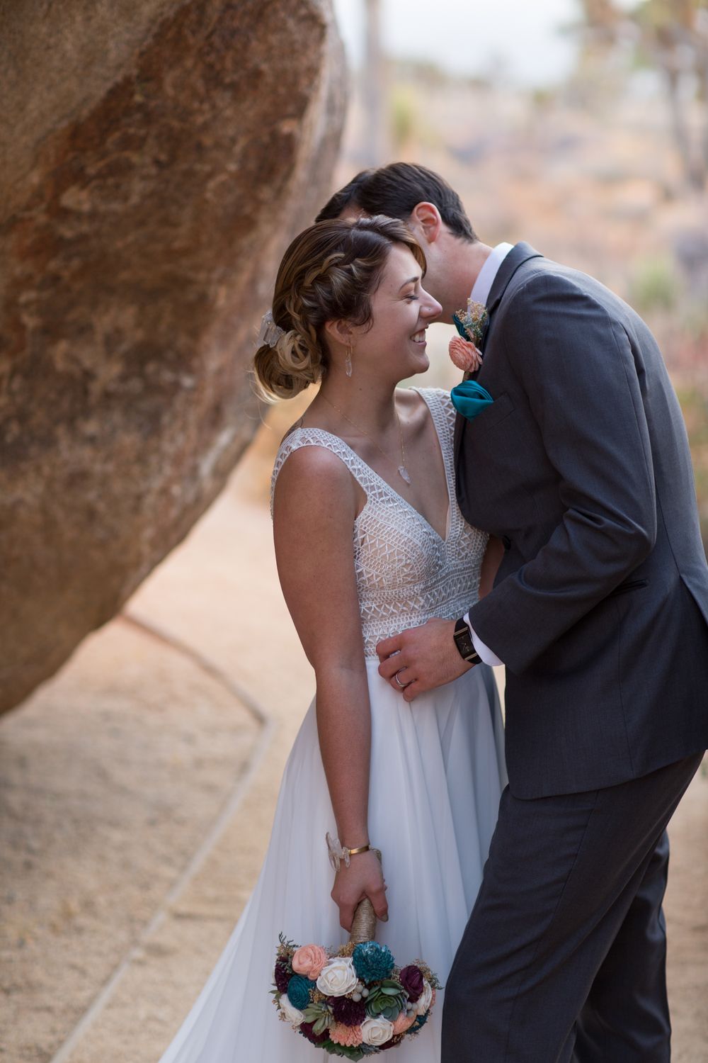 A young couple cuddles intimately after exchanging vows in Joshua Tree National Park in California.