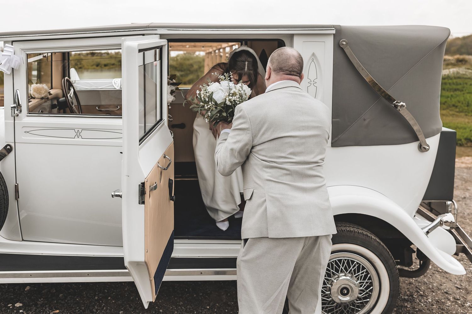 Relaxed, natural moment at Beverley Barn as Bride is helped from wedding car by her dad.