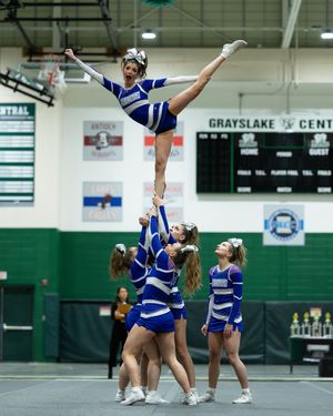 Cheerleader performs a high liberty stunt at Grayslake Central indoor cheer competition.