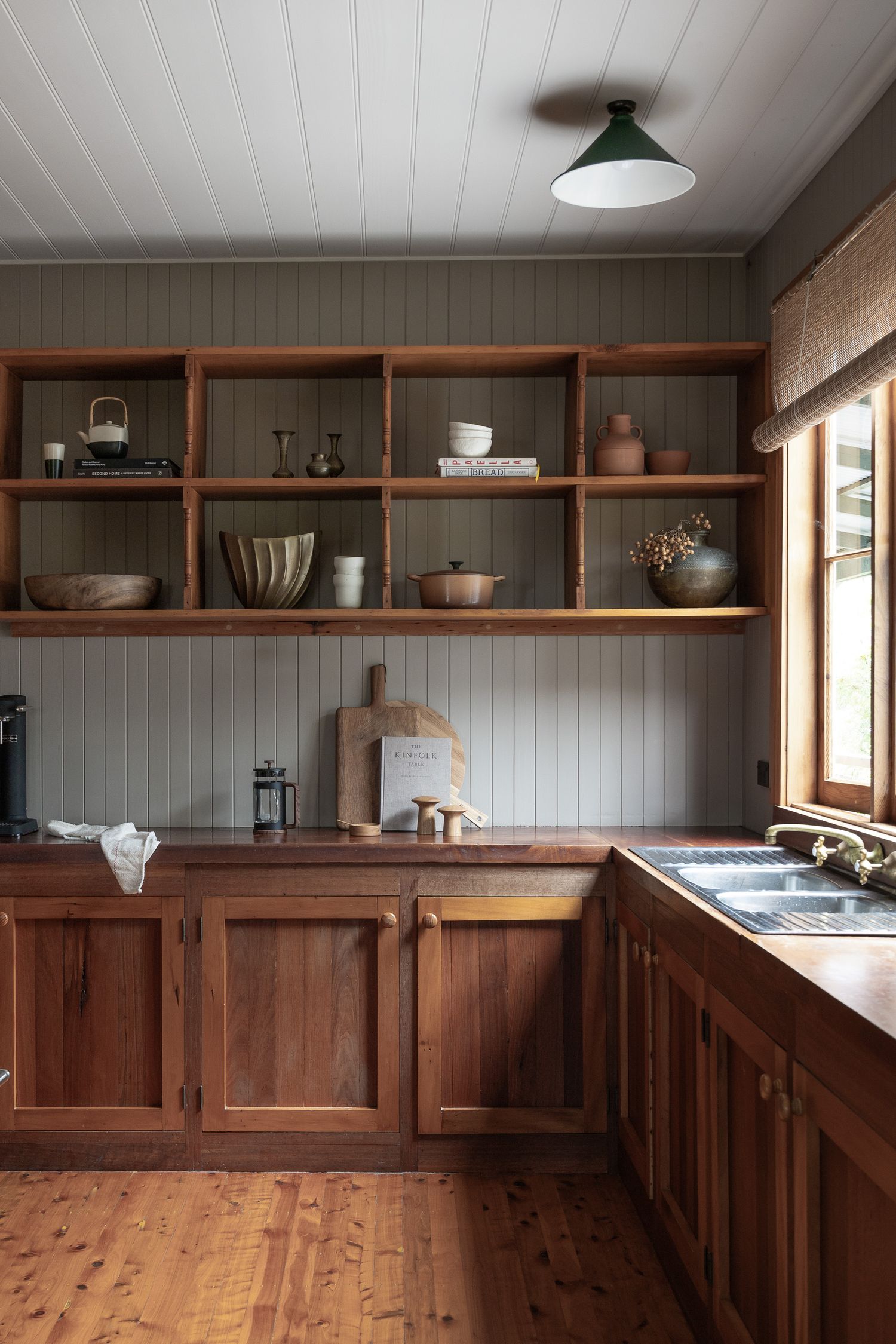 Warm timber kitchen interior photography with open shelving and natural light in a Hyams Beach coastal cottage.