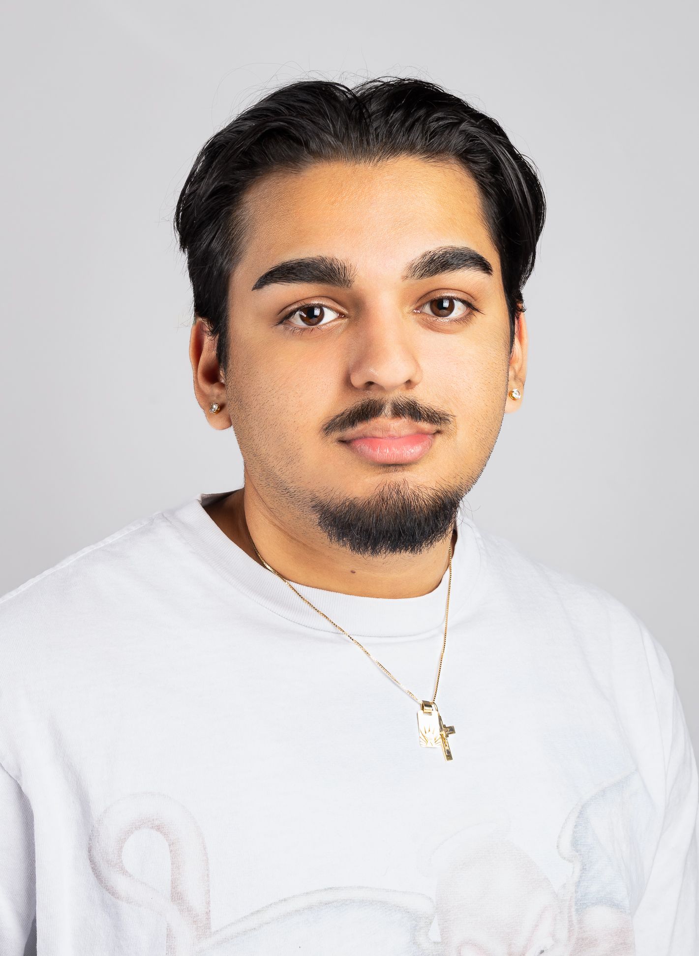 Image of a boy in a white shirt with a neutral expression looking at the camera