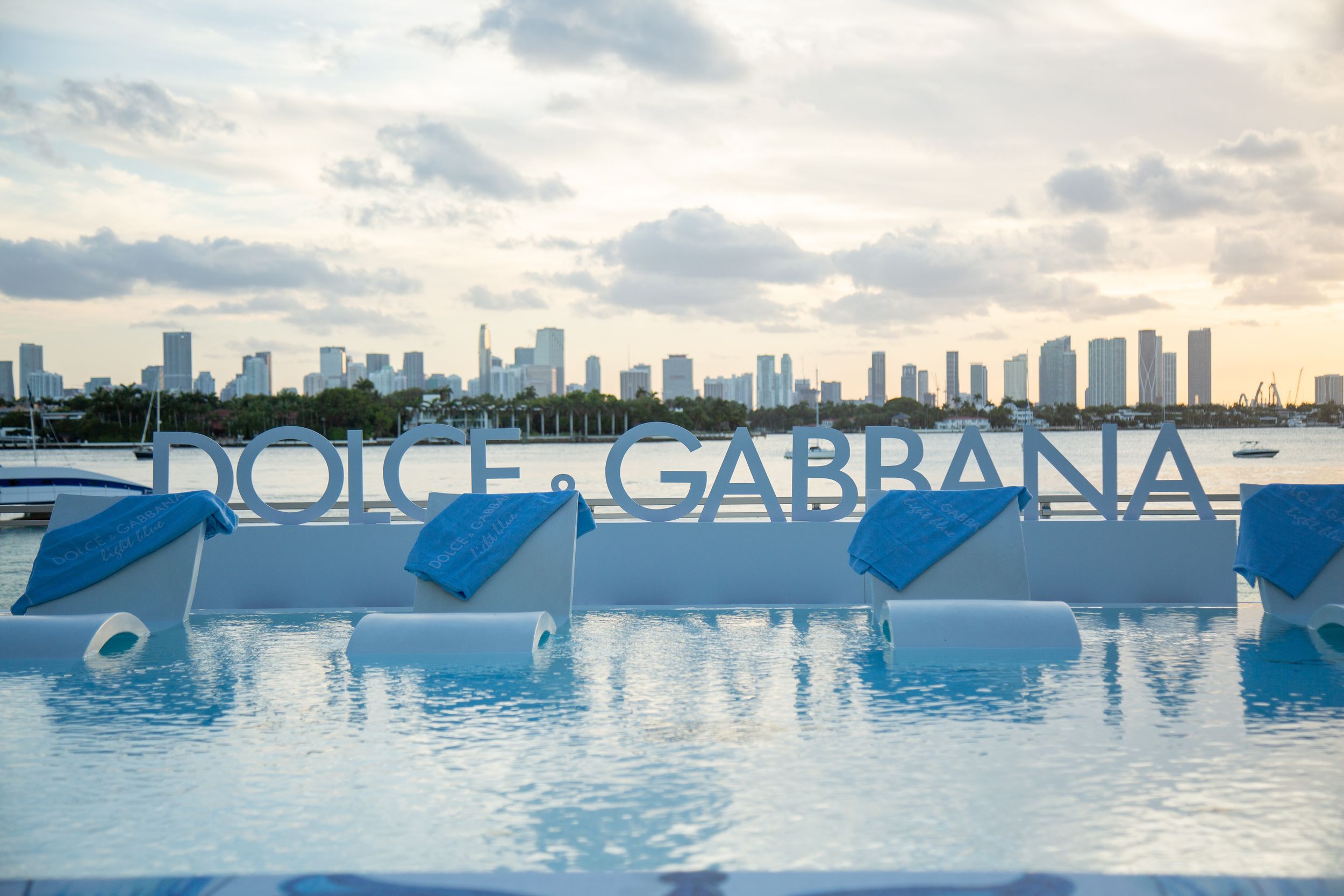 A panoramic series of waterfront views showing the Miami skyline and marina with boats against a cloudy sunset sky.