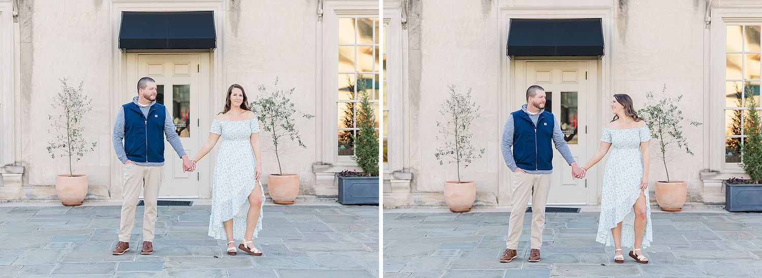 Wedding couple dances joyfully together outside a whitewashed building with French doors.