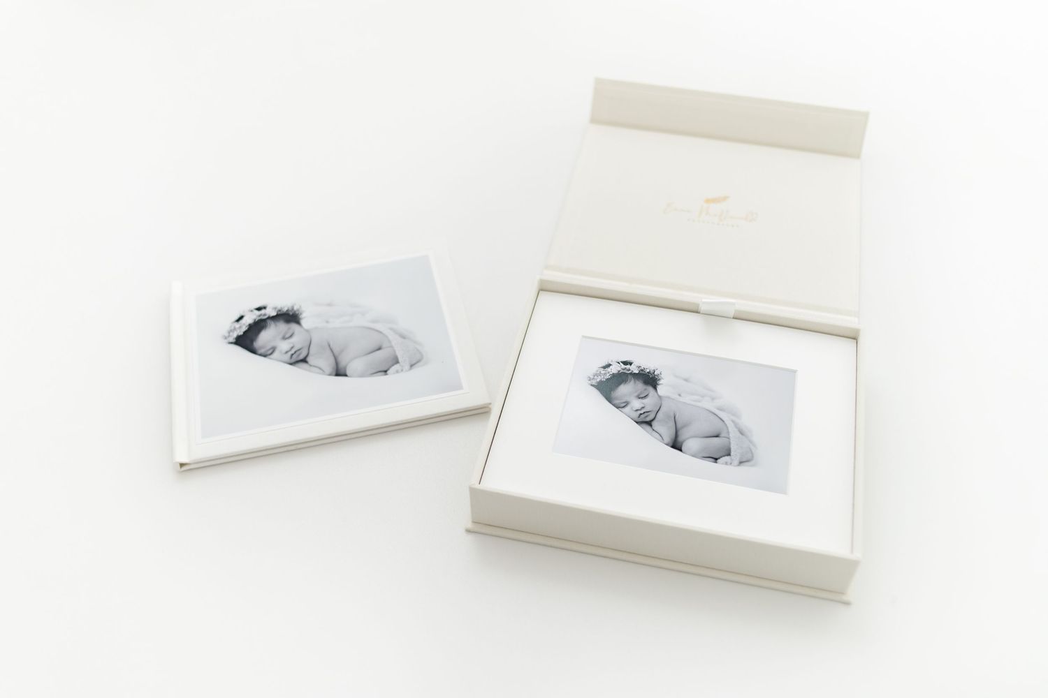 Two white presentation boxes containing black and white photo prints on white background.