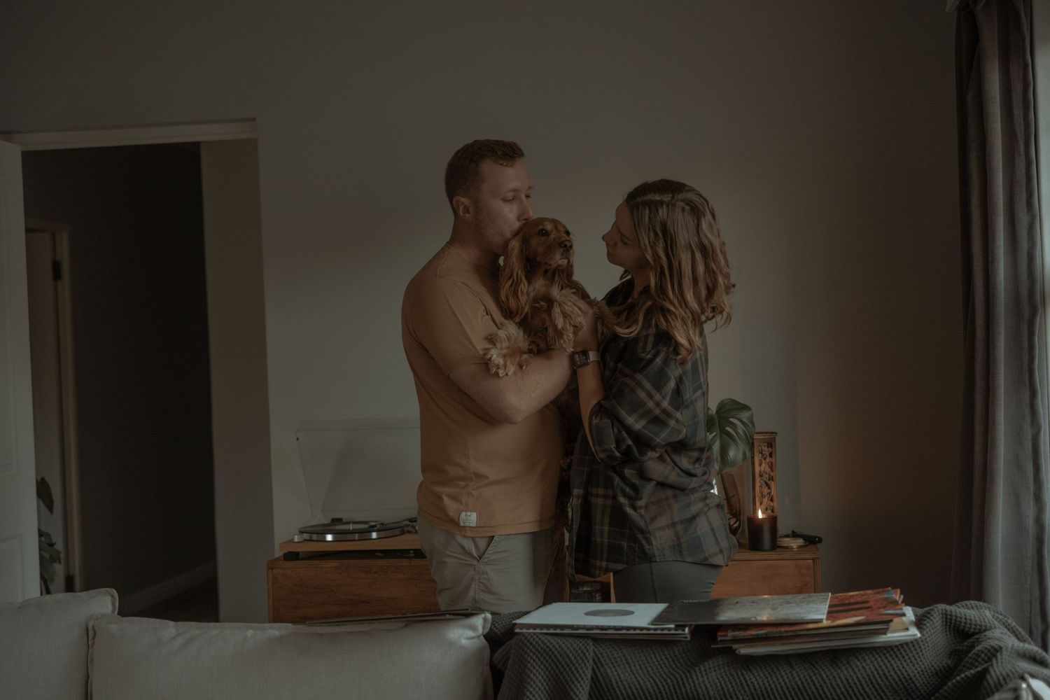An intimate family moment captured in dim lighting in a cozy home setting.