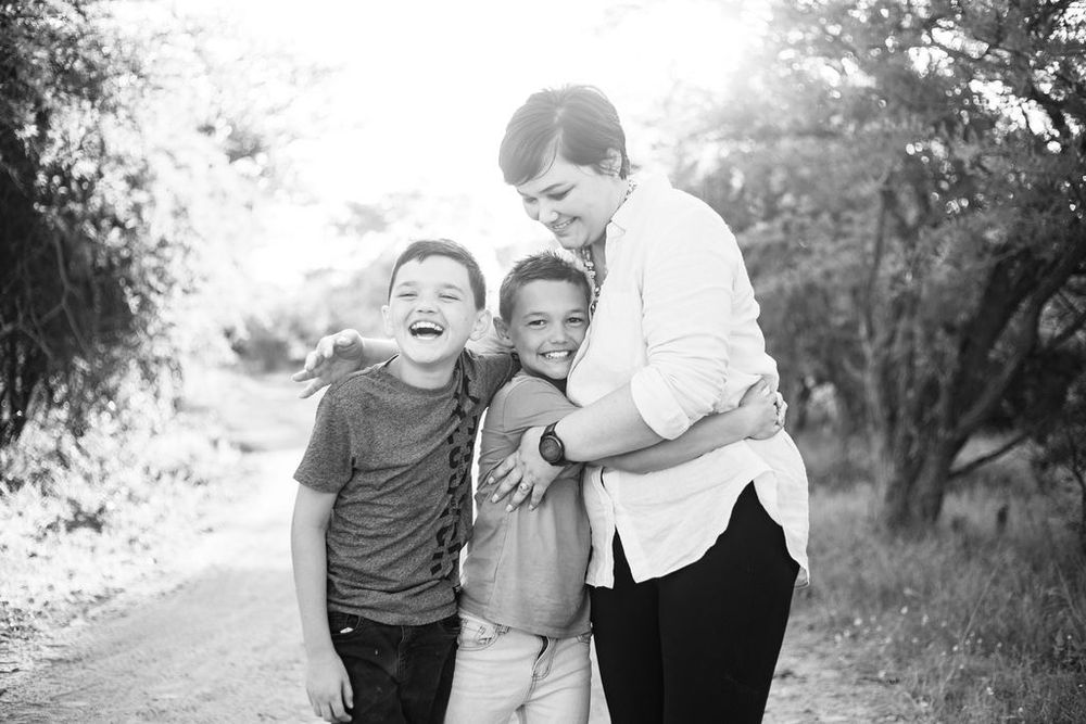 Black and white candid photo capturing joyful laughter on a nature path.