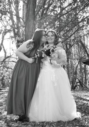 Natural light wedding photography capturing bridal party in gray dresses and white gown outdoors.