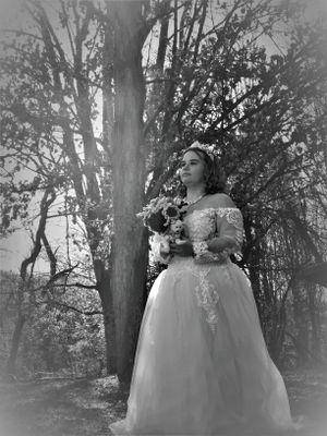 Dreamy forest photography features a person in an elegant white dress with natural light filtering through trees.