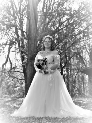 Monochrome bridal portraits featuring a flowing white wedding gown against a natural forest backdrop.