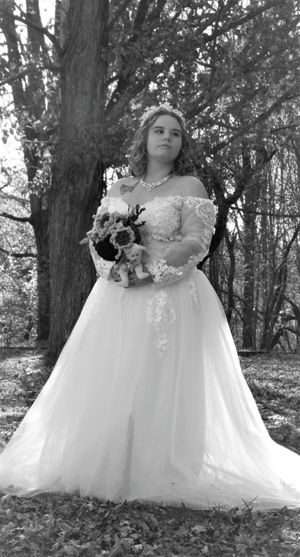 Artistic black and white photos of a bride in a lace detailed ballgown dress surrounded by autumn trees.
