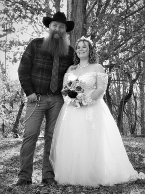 Casual outdoor wedding portraits showing the couple among trees with rustic styling elements.