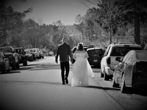 Black and white wedding exit photos with parked cars lining a tree-covered road.