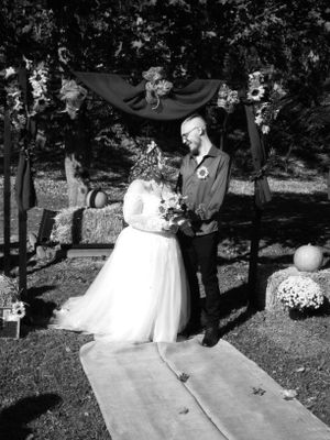 Wedding couple poses for romantic outdoor photos on a pathway surrounded by trees.