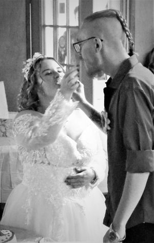 A tender moment between newlyweds as they feed each other cake at their wedding reception.