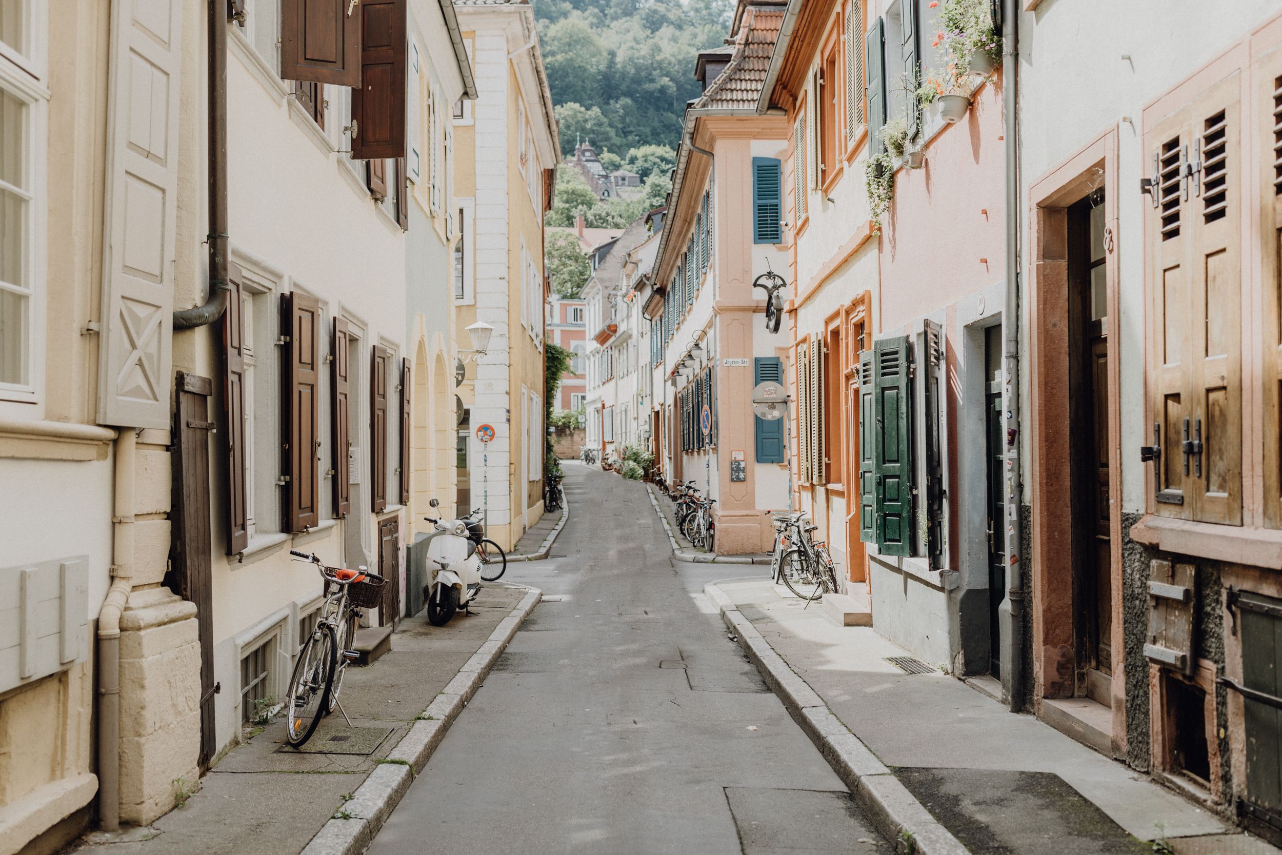 Altstadtgasse von Heidelberg, links und rechts sieht man die hellen Häuser mit bunten Klappläden.