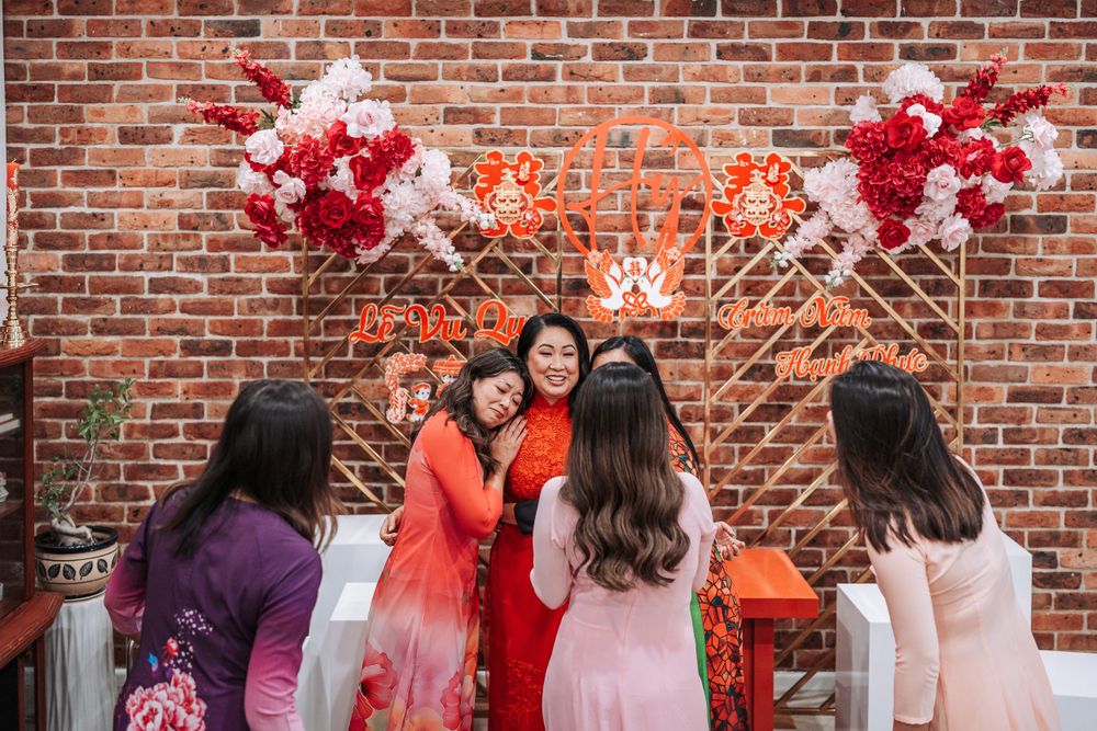Festive gathering with red balloon decorations against a brick wall backdrop.