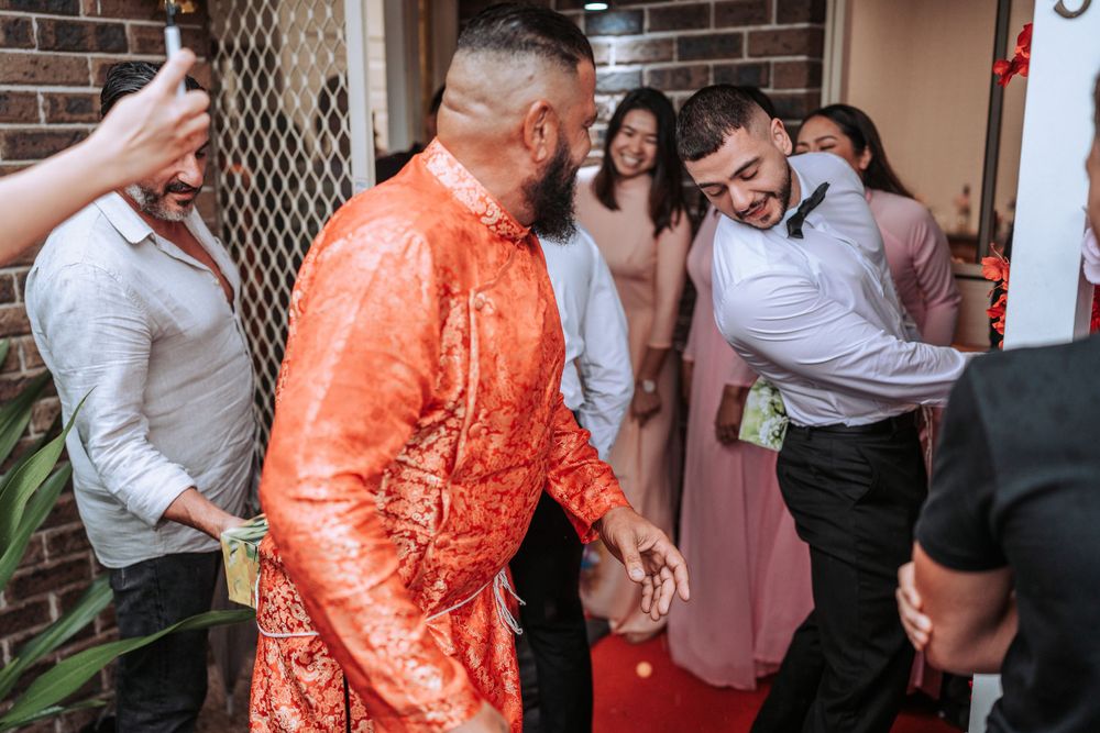 Wedding celebration with guests in traditional attire at a doorway entrance.