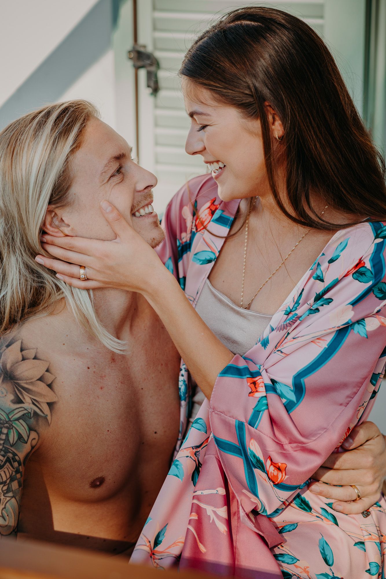 Close up shot of a loving couple sharing an intimate moment together, with one wearing a pink floral dress.