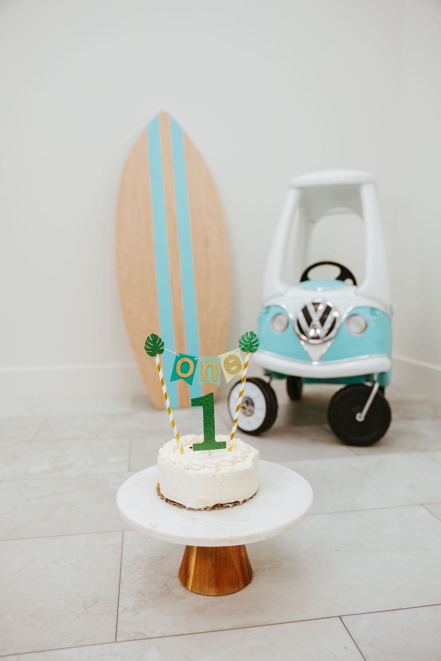 First birthday cake with surfboard and vintage VW bus decorations.