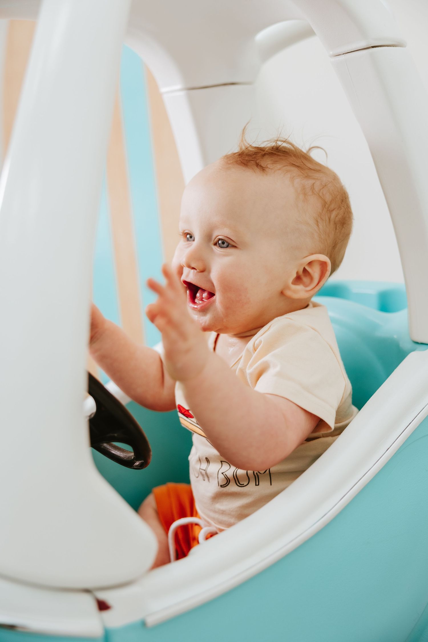 Joyful playtime inside a vintage-style light blue toy car.