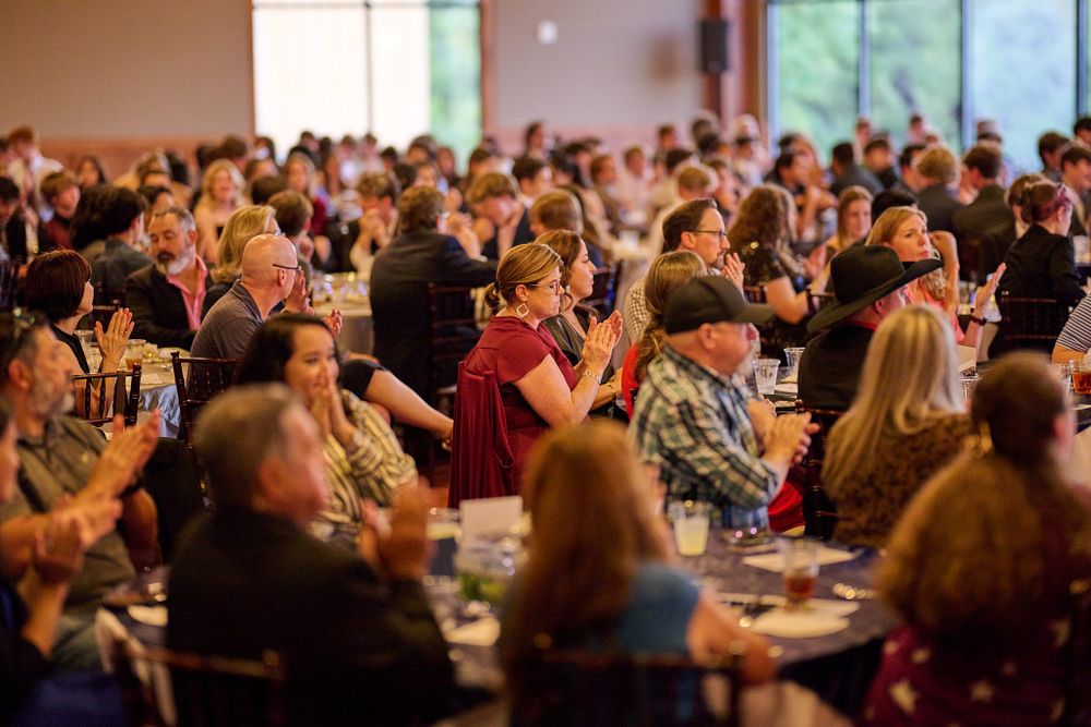 Large crowd gathered in a banquet hall during a formal event.