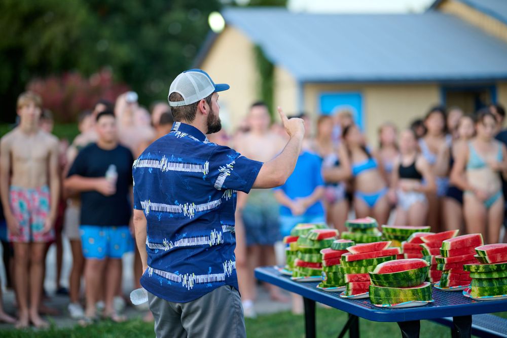 Trays of colorful beverages lined up and ready to be served at an outdoor event.