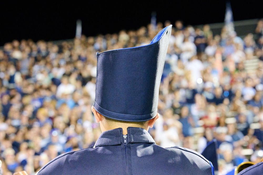 Crowded stadium bleachers filled with spectators in blue and white colors.