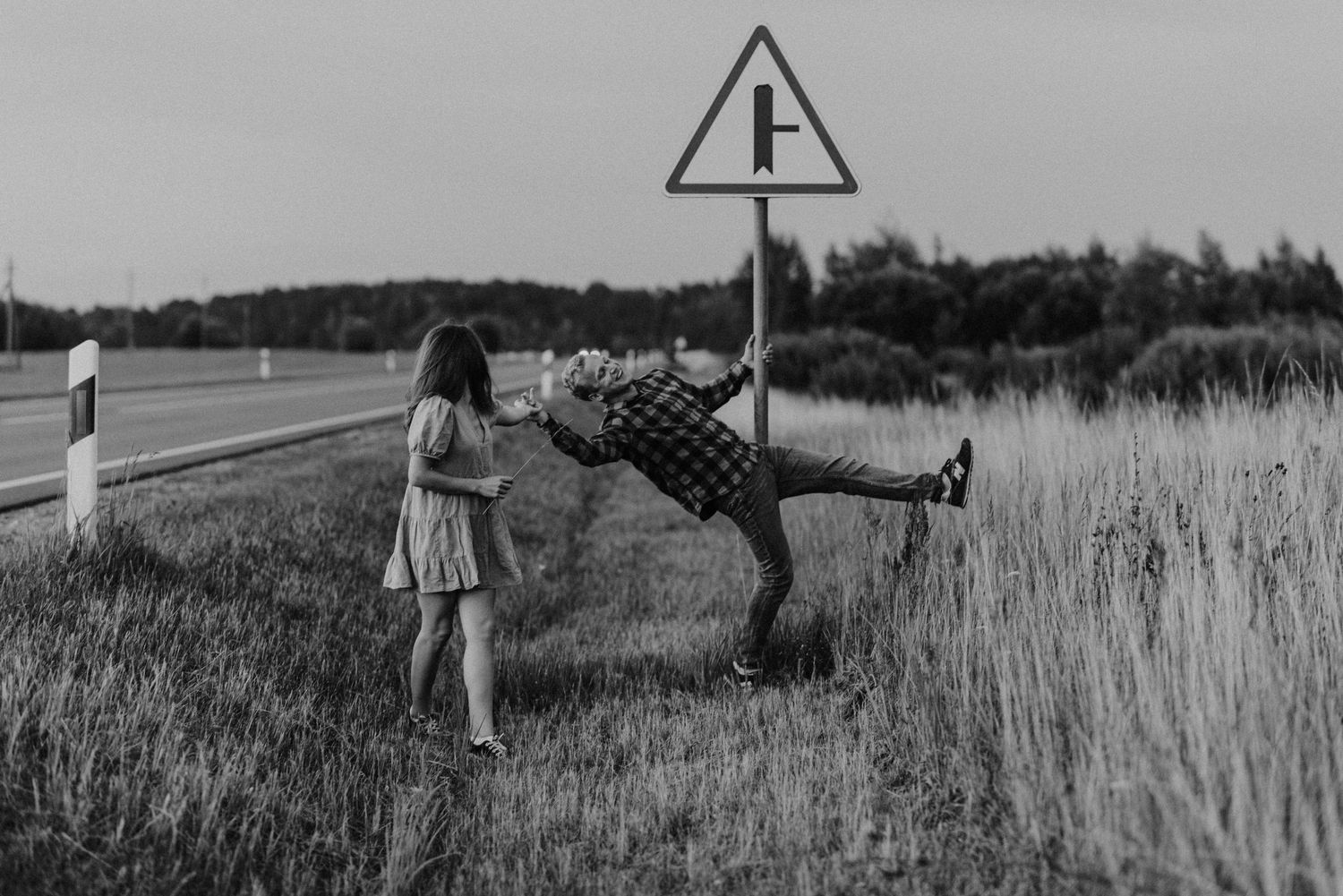 A series of black and white photographs showing a couple walking through a rural field at sunset.