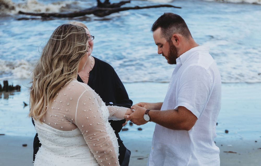 A couple shares an intimate moment during their beach wedding ceremony at sunset.