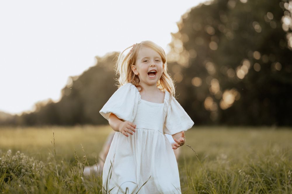 Kindershooting mit Mädchen Johanna, die lachend über eine Wiese rennt in Mengen Jovanna Burkard KWICKSHOT