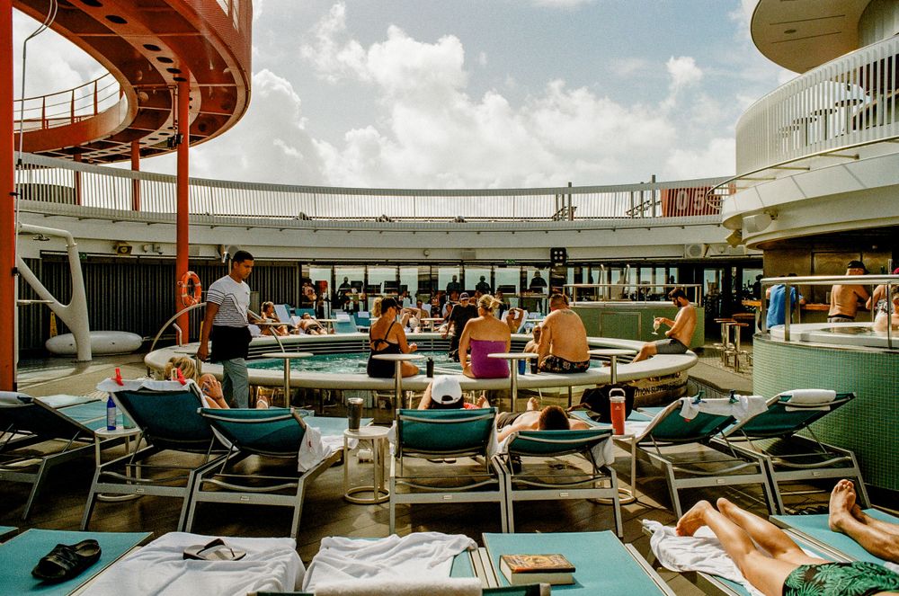Passengers relaxing on deck chairs aboard a vintage cruise ship with retro design elements.