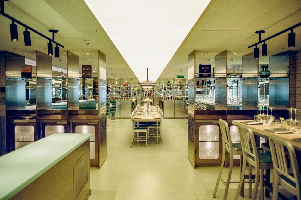 An empty science laboratory with parallel workbenches and overhead lighting stretching into the distance.