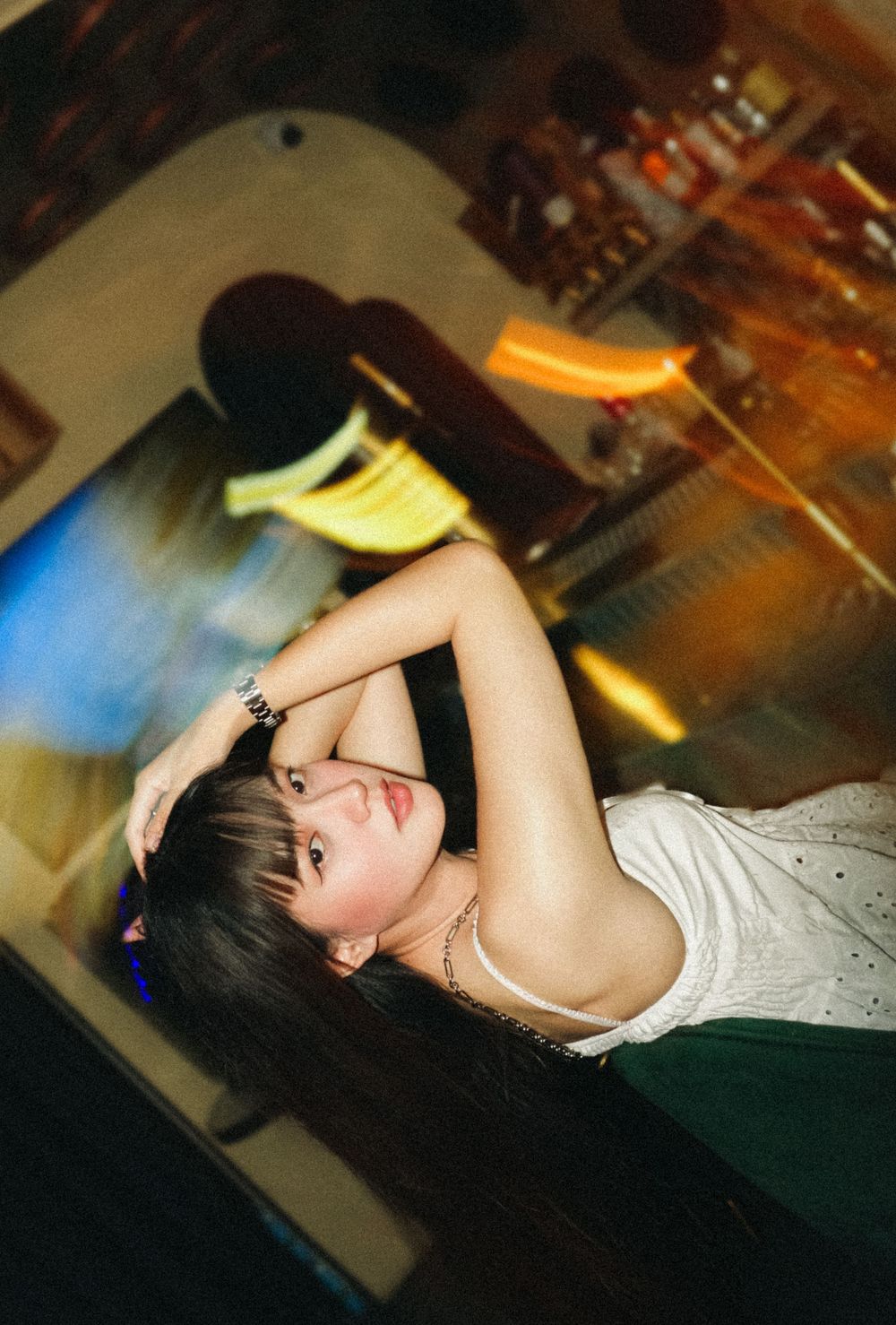 Person lying back in dramatic dance pose with dark lighting and stage effects in performance setting.