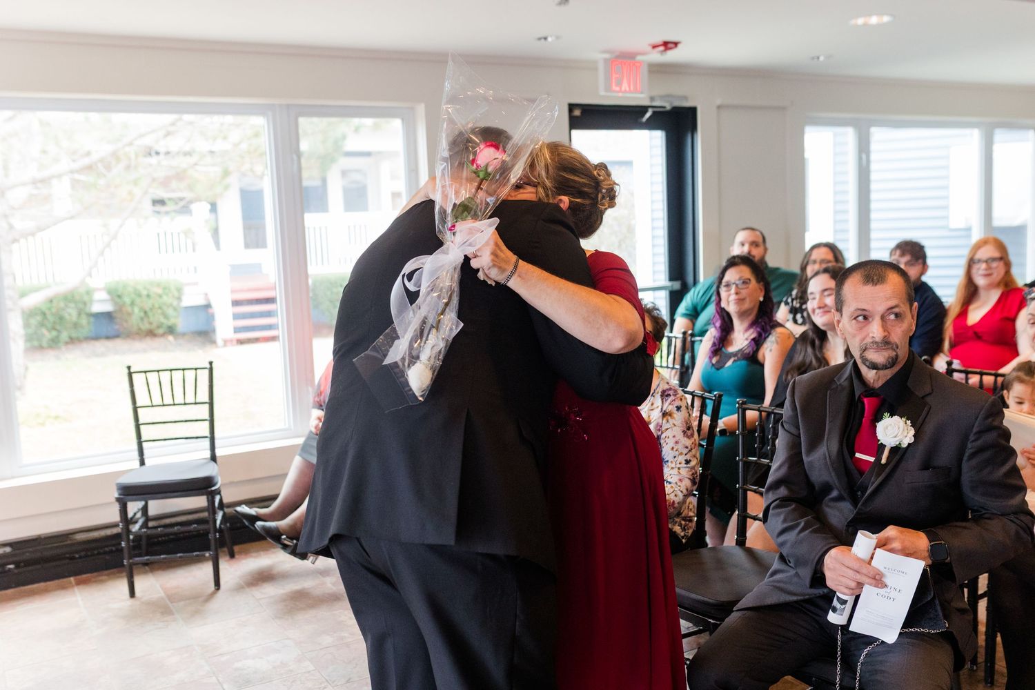 A group of people gather at an indoor event, mingling and socializing in a bright, modern space.