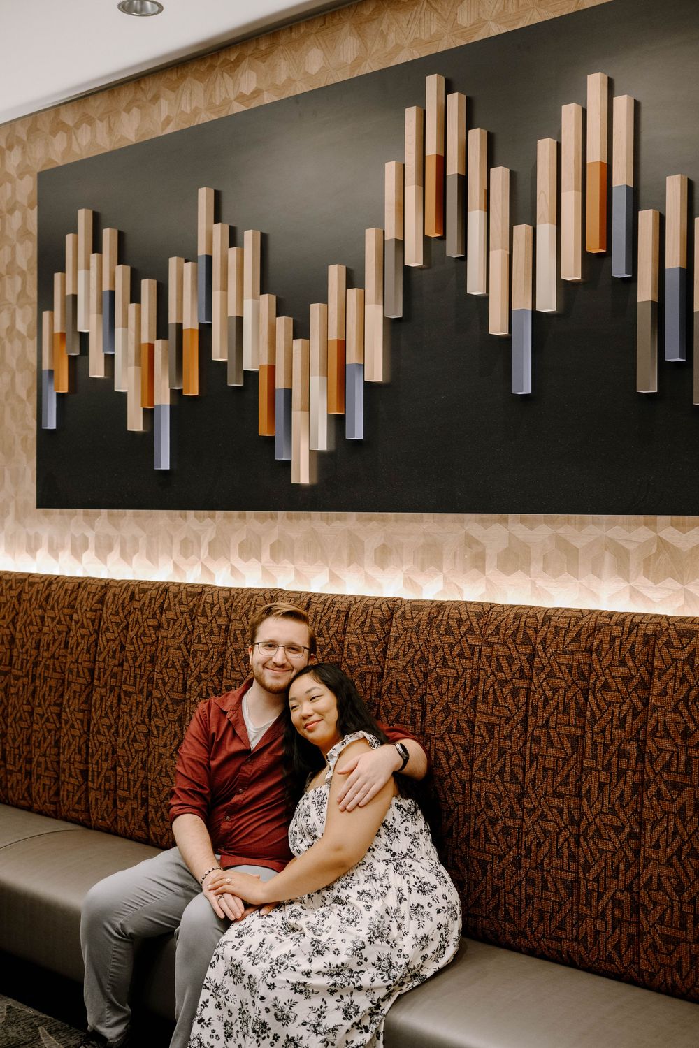 A romantic restaurant interior with modern wood panel decor and mood lighting on the wall.