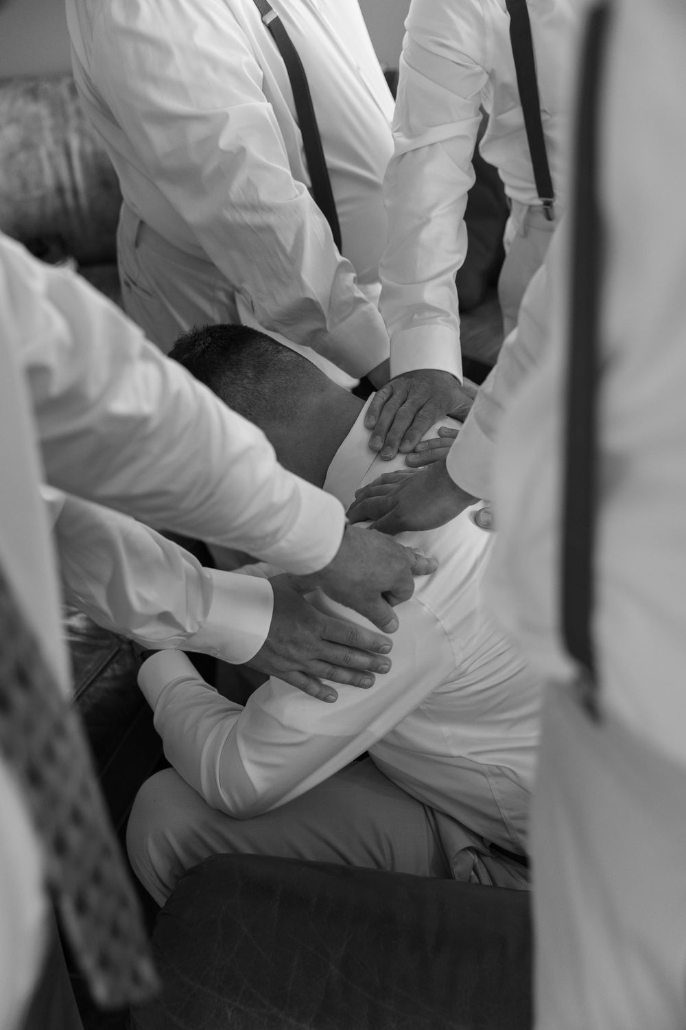 Black and white photo showing hands adjusting formal attire.