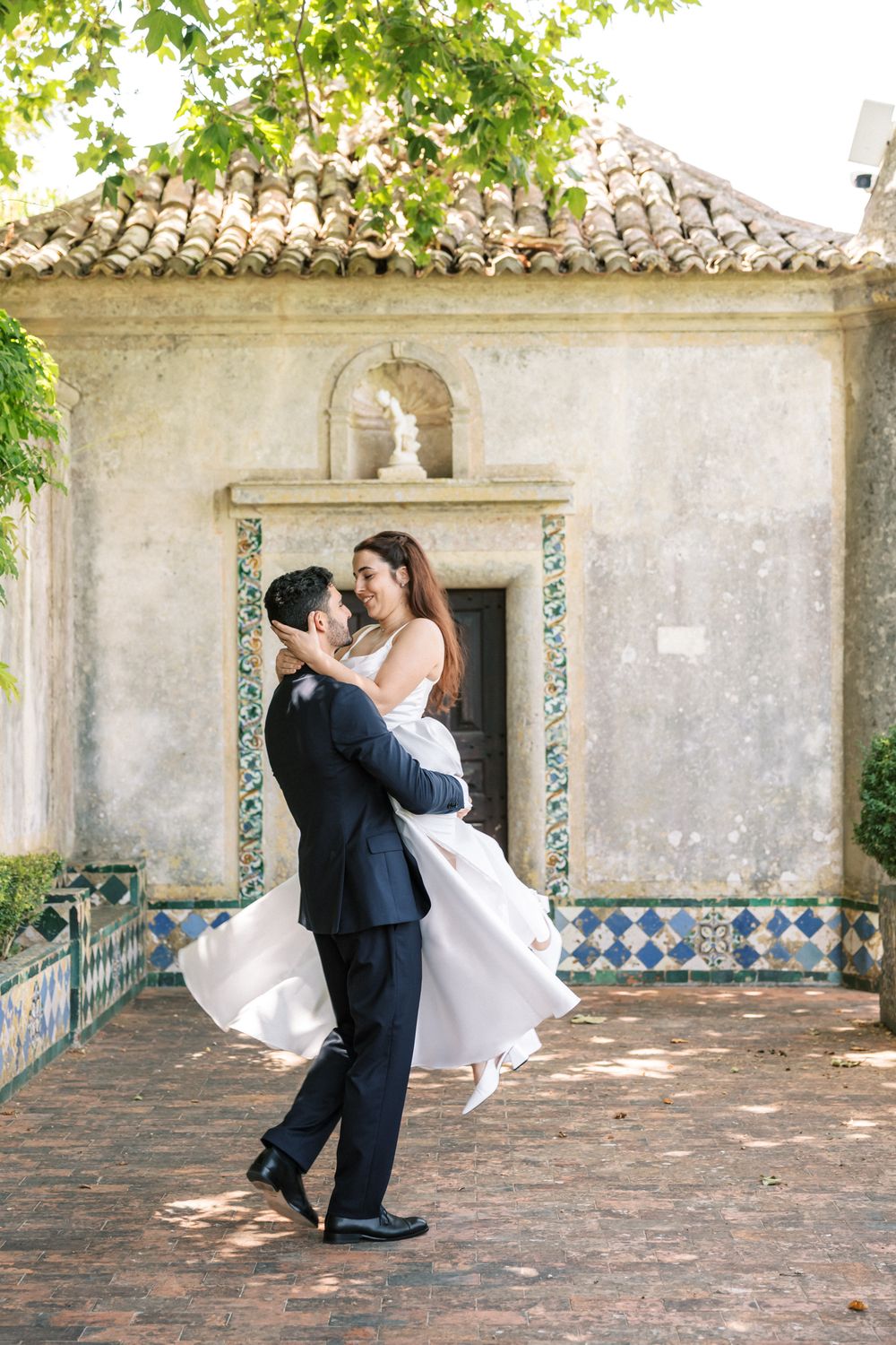 Romantic bride and groom spinning during destination wedding in Portugal