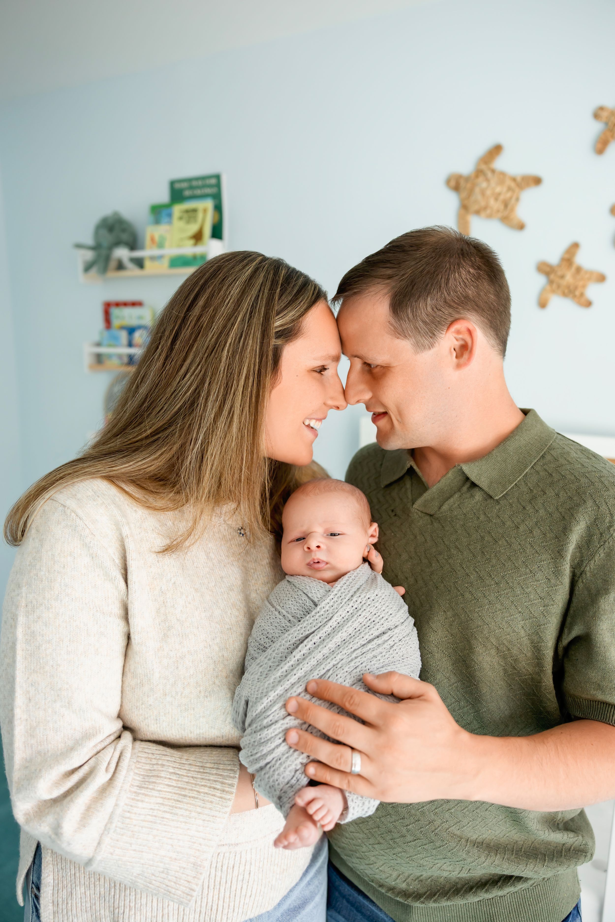 A series of intimate family moments showing affection while holding a baby in a cozy home setting.